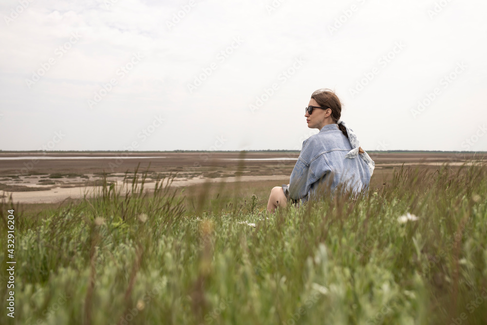 Young beautiful girl sitting on the background of nature. Young beautiful girl sitting on the background of nature.