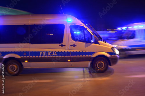 Specjalistyczny samochód policji polskiej w akcji nocnej pod stadionem piłki nożnej. 