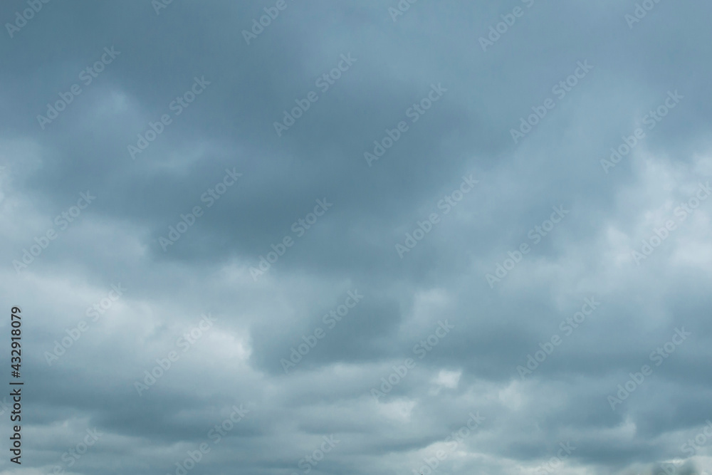 the sky with dense cumulus clouds is dark blue and gray with a texture for the background the sky with dense cumulus clouds is dark blue and gray with a texture for the background