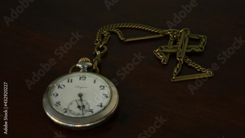 Time lapse of pocket watch showing time on wood table