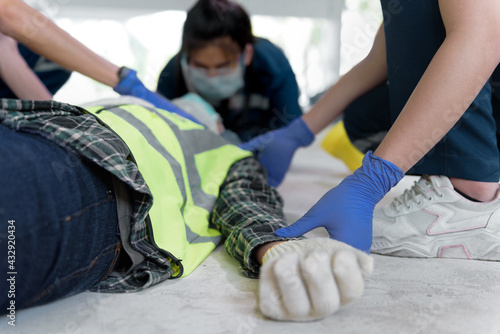 First aid team take a pulse for check injuries and Considered for all trauma incidents of worker in work, Loss of feeling or loss of normal movement. First aid training to transfer patient. photo