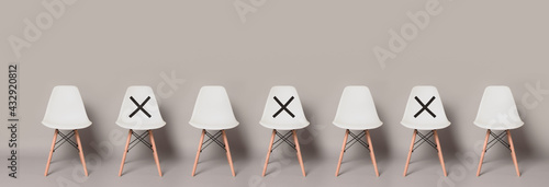 Empty Modern White Chair Standing Row with Symbol on Chair to Keep Your Distancing on Light Gray Colour Banner Size Background with copy space., Protective Coronavirus (COVID-19) Concept photo