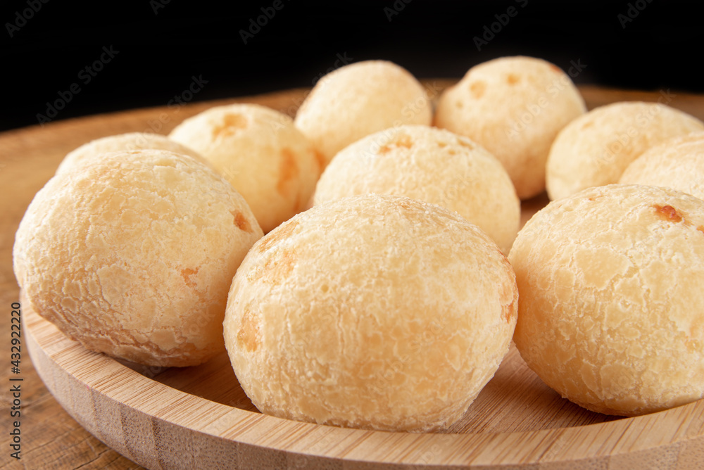 Brazilian Cheese bread, cheese breads arranged on wooden plate, on rustic wood, selective focus.