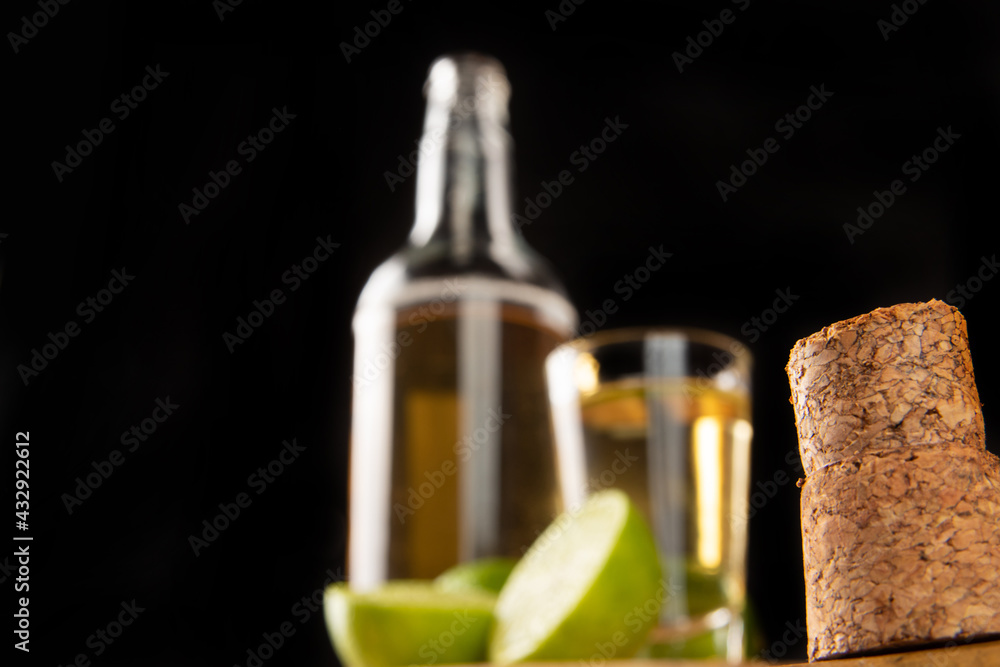 Obraz premium Brazilian drink known as Cachaça, in the foreground a cork and in the background cachaça, a drink from sugar cane. It is used in the preparation of the caipirinha known worldwide, selective focus.