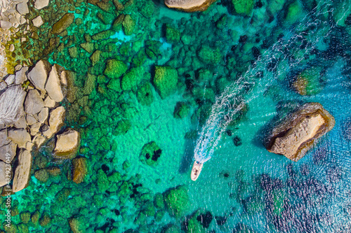 Vue en drone d'un bateau de plaisance navigant sur les eaux tuquoises de Bonifacio photo