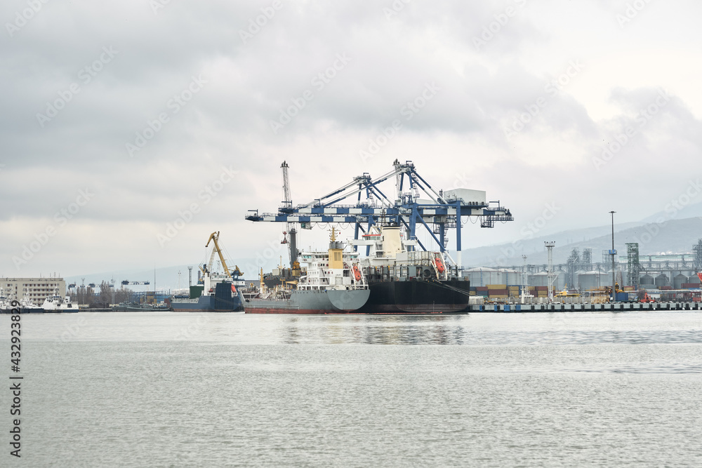 The mooring front of the seaport with moored bulk carriers. Ships are being loaded and unloaded. Copy space. The mooring front of the seaport with moored bulk carriers. Ships are being loaded and unloaded. Copy space.