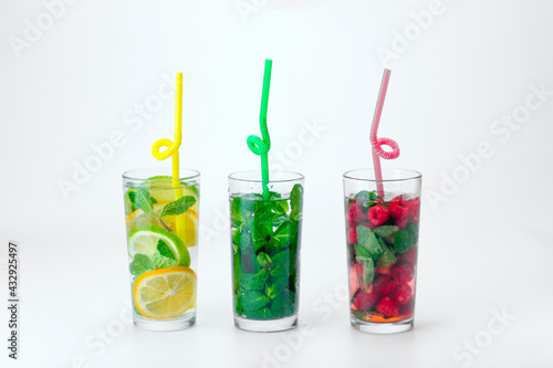 Cocktails isolated on white background. Lemon and lime, mint and raspberries cocktails.