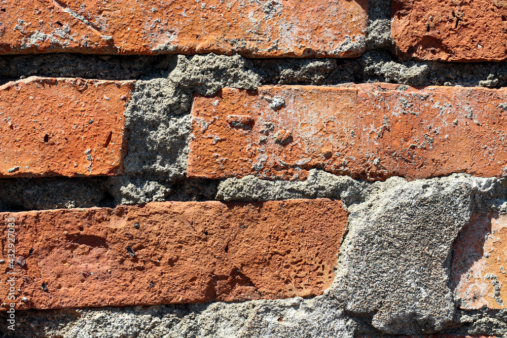 Old weathered orange brown brick background with gray cement elements Old weathered orange brown brick background with gray cement elements
