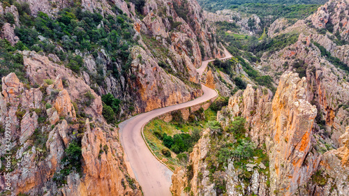 The Calanches de Piana, Drone view of the road between the mountains. The Calanches de Piana are a geological formation of red porphyry of volcanic origin with magmatic rocks.  photo