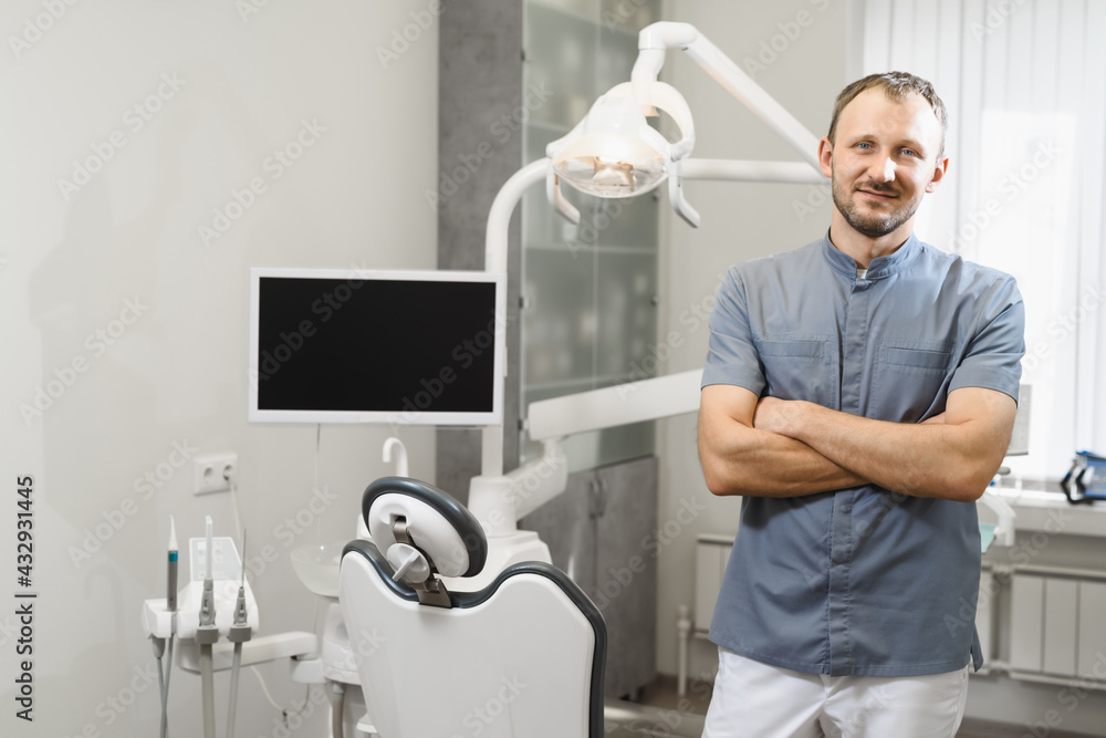Obraz premium Portrait of a friendly male dentist in his office. Modern dental clinic.