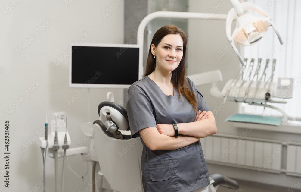 Portrait of a friendly female dentist in her office. Modern dental clinic.