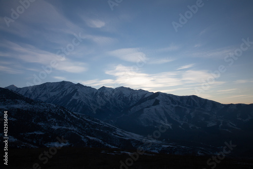 Landscape in the mountains at sunset. View of the misty hills hidden behind the oncoming darkness © justoomm