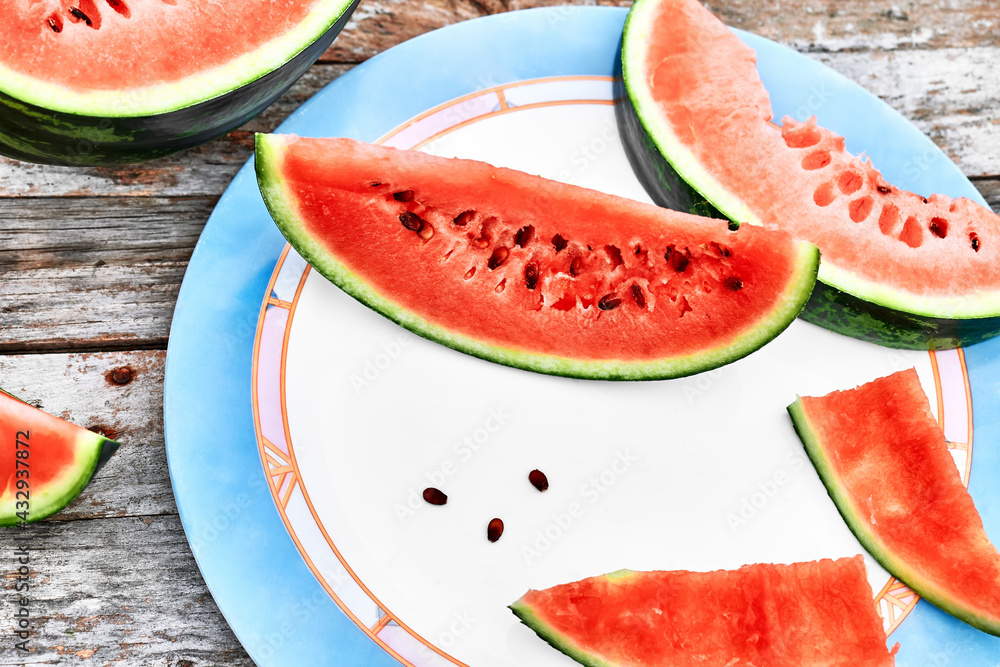 Slices of ripe fresh watermelon on wooden table outdoor. Healthy eating summertime concept. Organic fruits. Slices of ripe fresh watermelon on wooden table outdoor. Healthy eating summertime concept. Organic fruits.