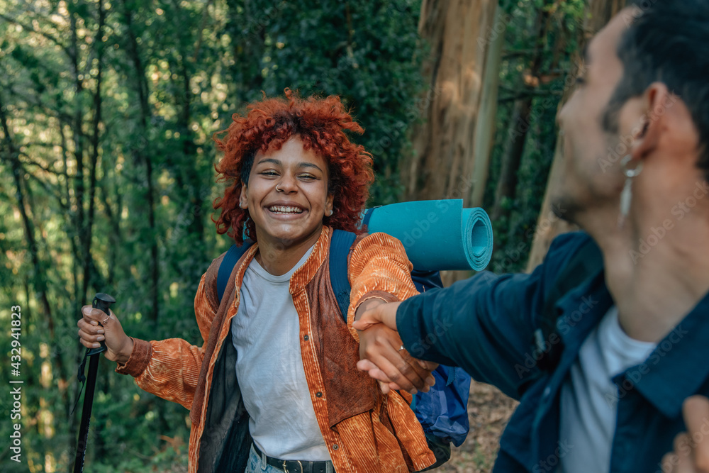 young people holding hands helping each other hiking