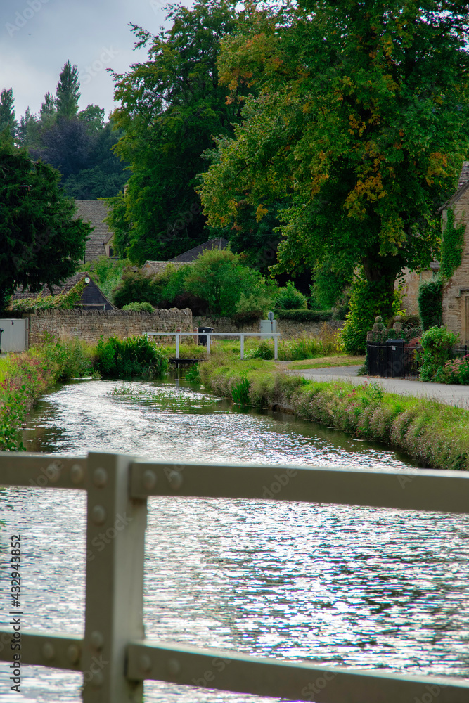 The Cotswolds in early autumn, seen over the parapet of a bridge, at Lower Slaughter.