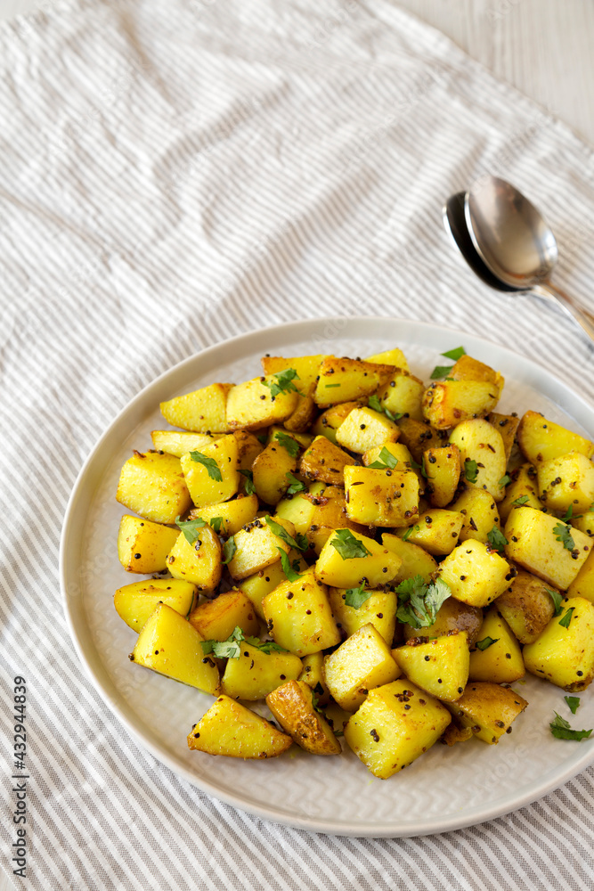 Homemade Roasted Potatoes with Mustard Seeds on a Plate, side view. Copy space. Homemade Roasted Potatoes with Mustard Seeds on a Plate, side view. Copy space.