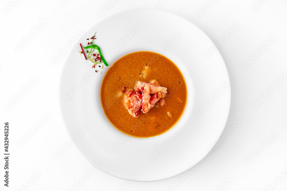 Delicacy spicy cream seafood soup with crab meat. Banquet festive dishes. Gourmet restaurant menu. White background. Delicacy spicy cream seafood soup with crab meat. Banquet festive dishes. Gourmet restaurant menu. White background.