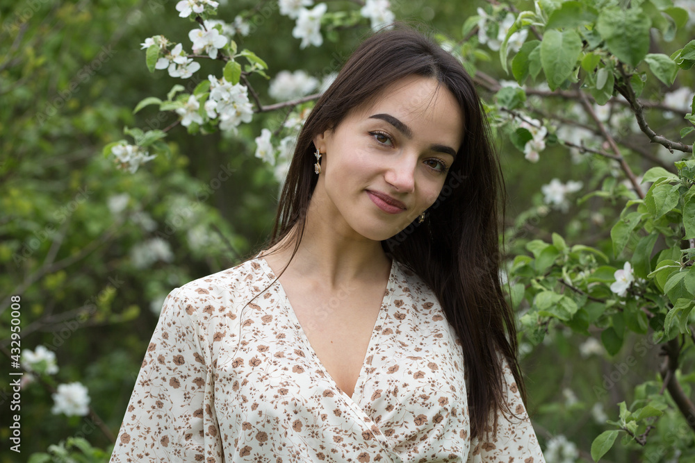 Portrait of a positive cheerful brunette girl in a green spring park. Portrait of a positive cheerful brunette girl in a green spring park.