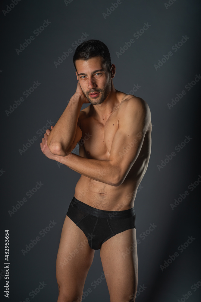 Fashion close-up portrait of a handsome male with bare torso posing in black underwear on isolated background Fashion close-up portrait of a handsome male with bare torso posing in black underwear on isolated background
