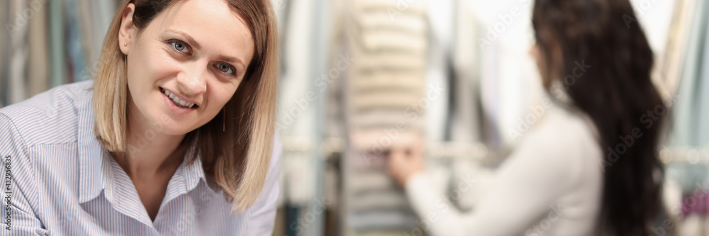 Female salesman records list of the selected goods in documents on clipboard Female salesman records list of the selected goods in documents on clipboard