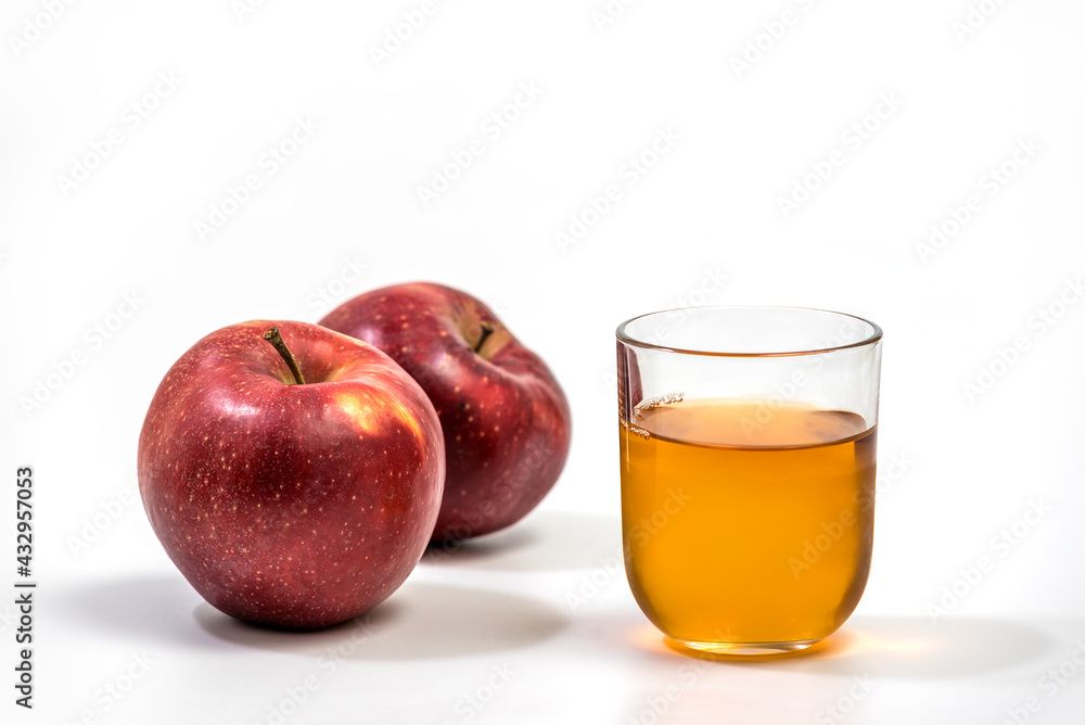 Close up of a glass of apple juice, with a whole and half apple. Natural apple juice on white background Close up of a glass of apple juice, with a whole and half apple. Natural apple juice on white background