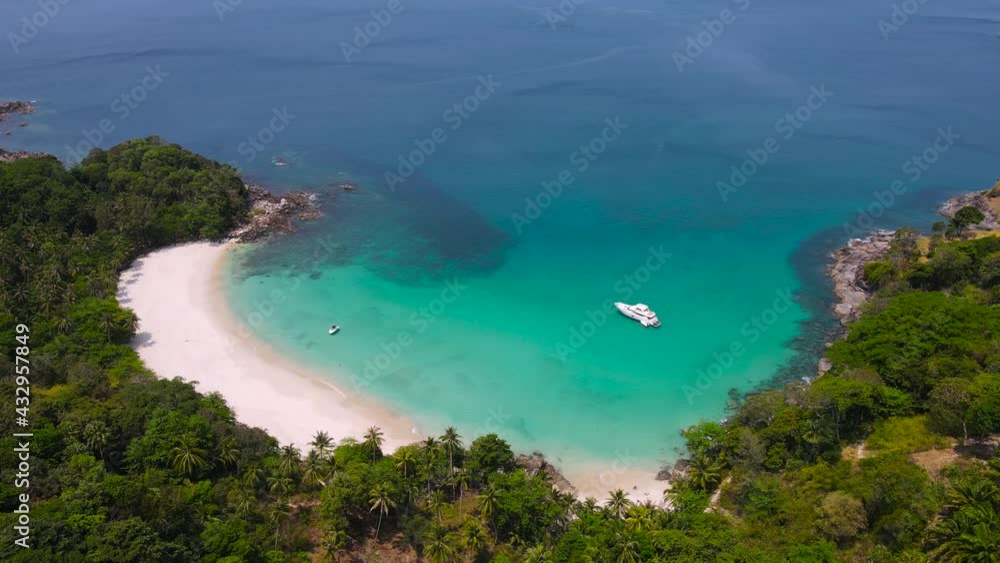 Professional Video 4K. Aerial view shot. Drone camera over white beach sand and sew water clear. Nature video view of beautiful tropical beach and yacht at sea. Freedom beach. At Phuket, Thailand. Professional Video 4K. Aerial view shot. Drone camera over white beach sand and sew water clear. Nature video view of beautiful tropical beach and yacht at sea. Freedom beach. At Phuket, Thailand.