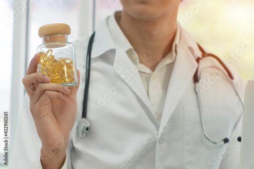 Pharmacist or Physician medicine doctor holding or showing a bottle of pills in hand after invented a new drug. Concept of  health insurance and medical care