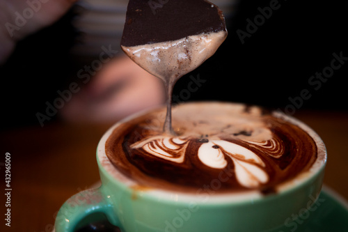 Chocolate Melts and Drips Into Hot Chocolate Drink at Local Cafe photo