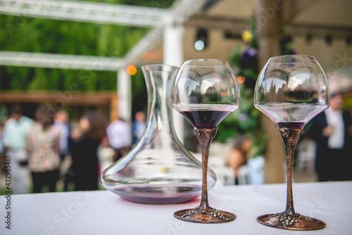 Foto Arrangement with 2 coups of red wine and glass jar in a outdoor wedding in the d