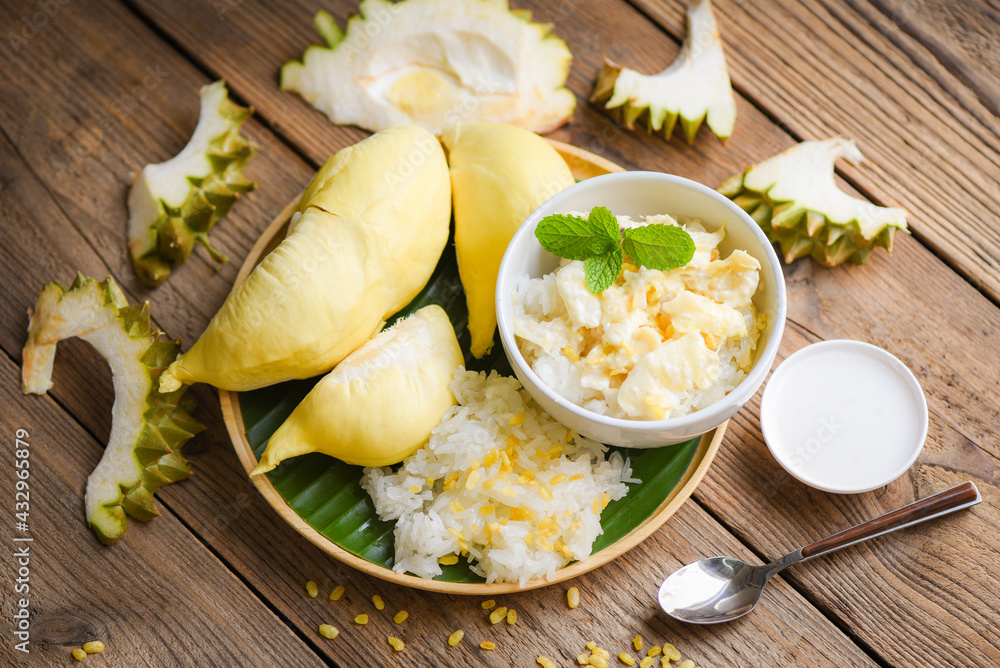Ripe durian rice cooked with coconut milk, Asian Thai dessert tropical sweet durian peel with yellow bean on white plate on the wooden table and fresh mint leaves, Durian sticky rice summer fruit food Ripe durian rice cooked with coconut milk, Asian Thai dessert tropical sweet durian peel with yellow bean on white plate on the wooden table and fresh mint leaves, Durian sticky rice summer fruit food