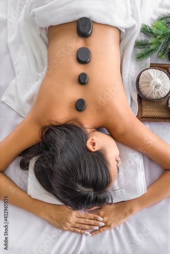 woman ralax with hot stone massage treatment and therapy in spa salon