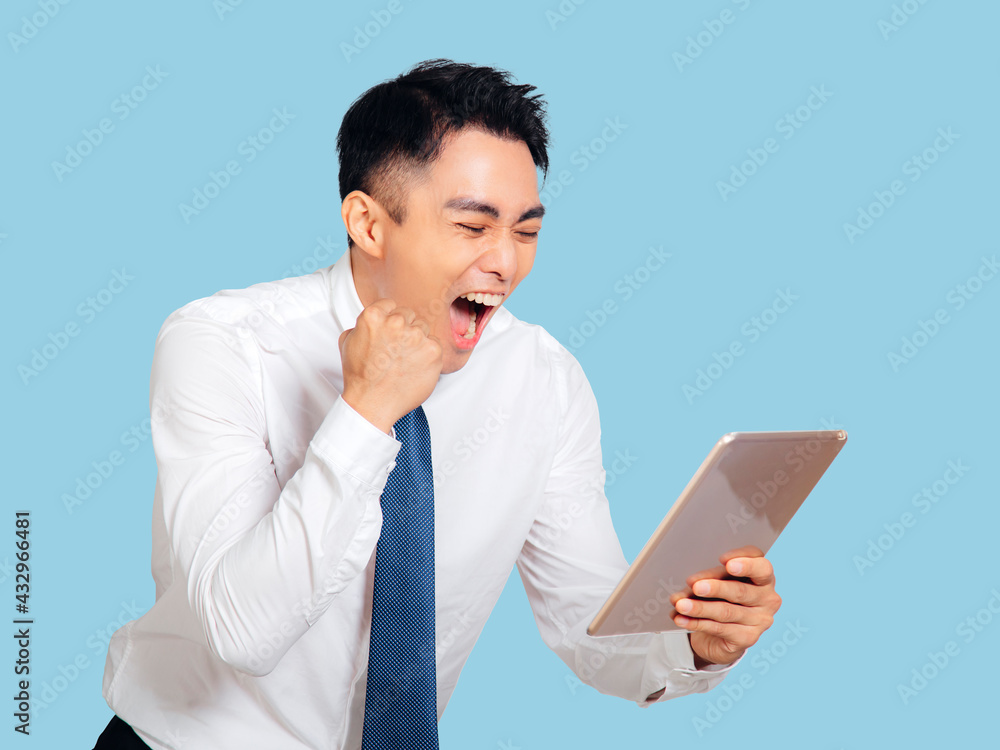 Excited young business man watching the tablet