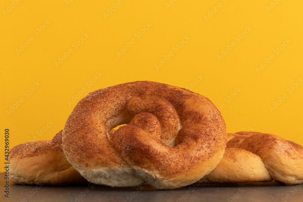 delicious cinnamon pretzels on yellow background. delicious cinnamon pretzels on yellow background.