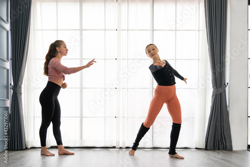 Female ballet teachers training ballerina to have right postures in the private class at home studio. Choreographer teaching caucasian dancers to movements of modern music. Concept of dance rehearsal