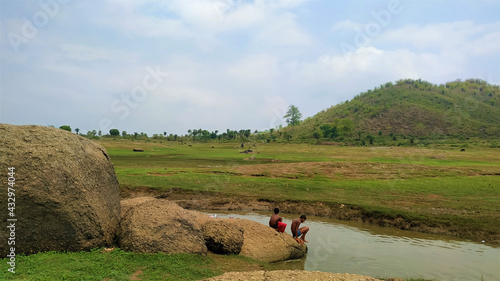 indian village level children enjoying at river with Beautiful mountain background view photo