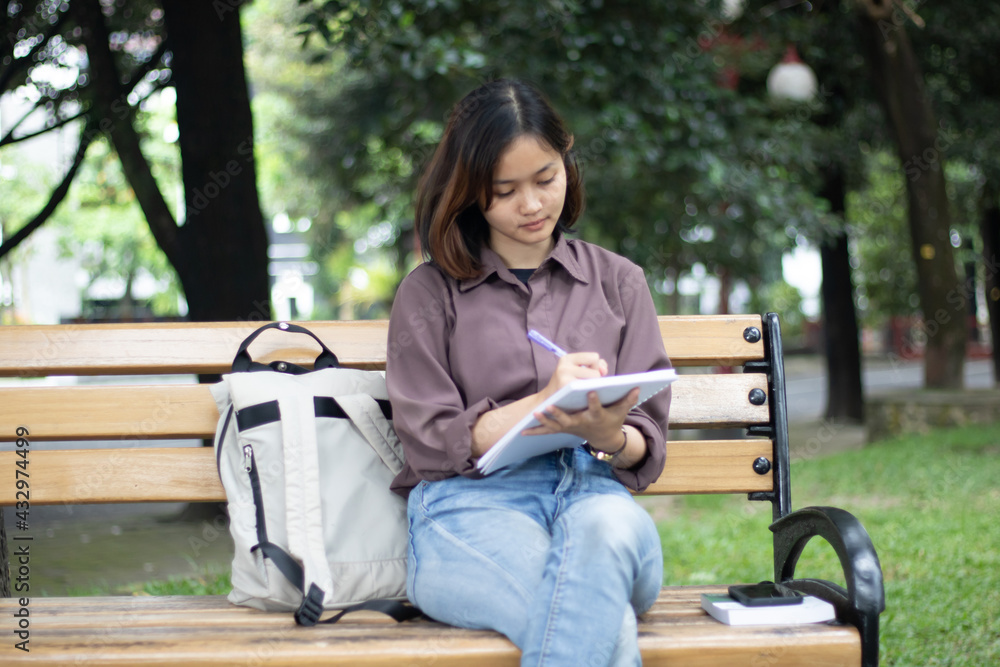 Young woman studying at the park. Young woman studying at the park.
