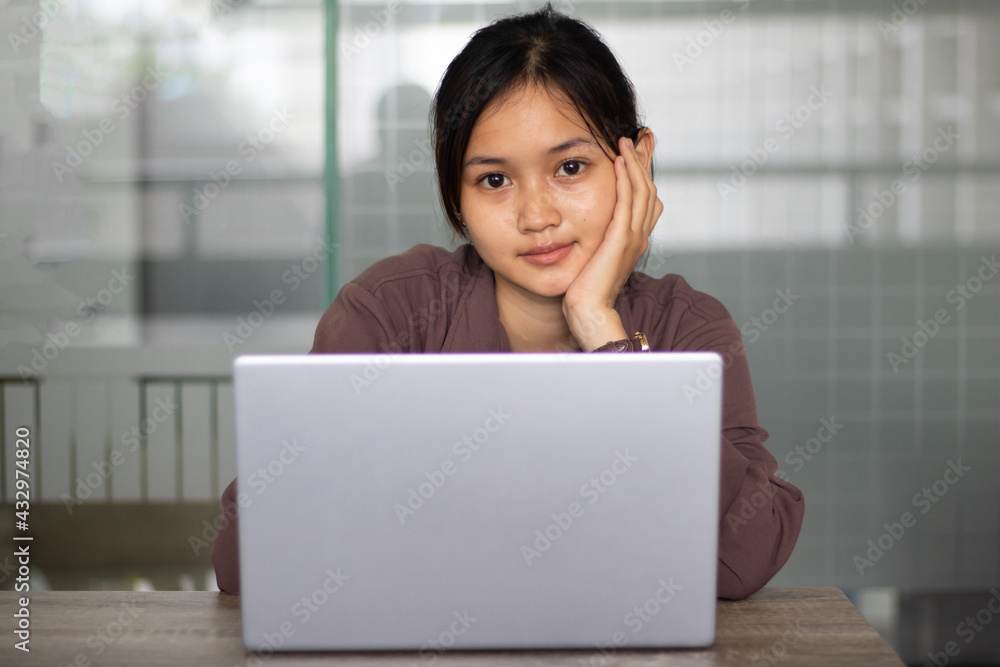 Attractive happy young girl student studying at the college library having video chat. Attractive happy young girl student studying at the college library having video chat.