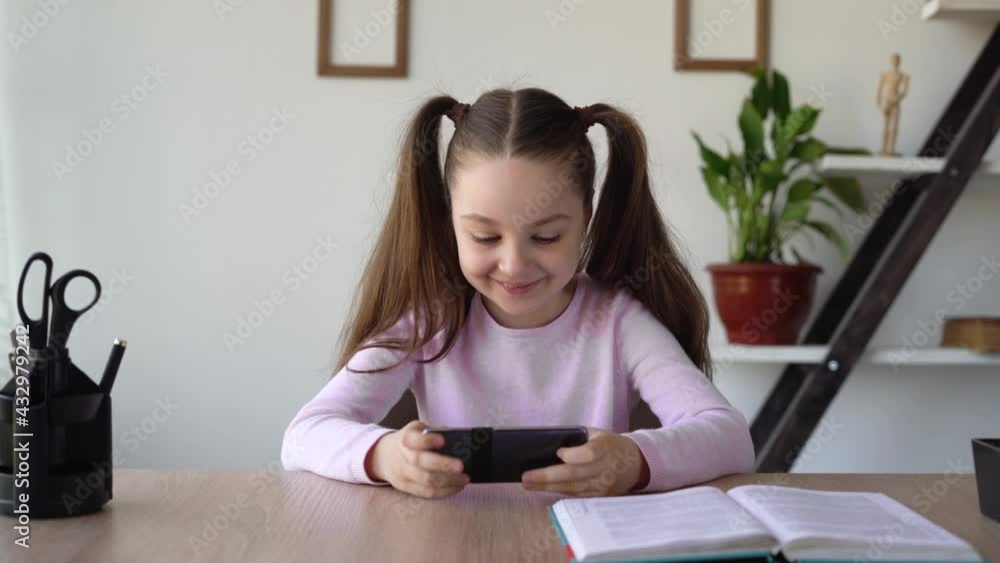A child addicted to the Internet and gadgets playing mobile games sitting at home tired of studying and learning online.The problem of children's addiction