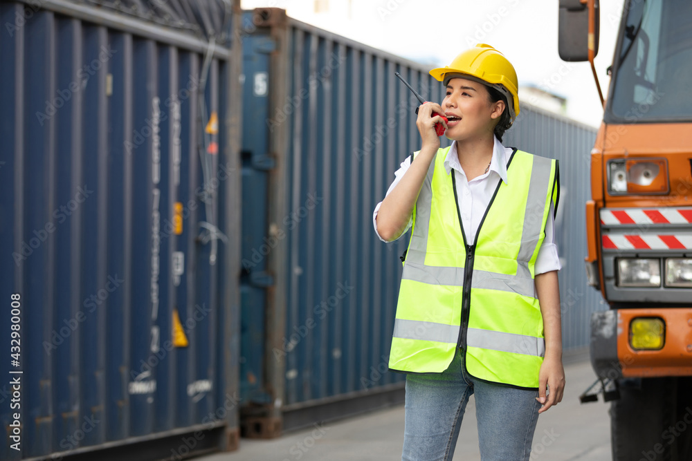 woman factory worker or engineer using walkie talkie for preparing a job in containers warehouse storage woman factory worker or engineer using walkie talkie for preparing a job in containers warehouse storage