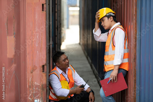 two factory workers or engineers resting and preparing for a job in containers warehouse storage