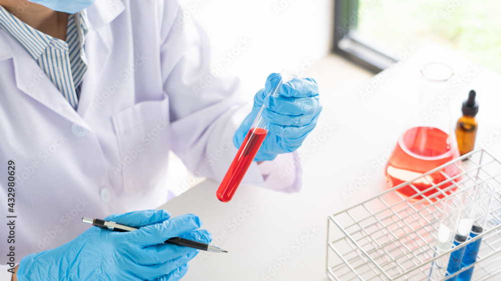 Young Asian scientist Working looking through a microscope doing research for analyzing a Experiments sample in a forensic laboratory. Young Asian scientist Working looking through a microscope doing research for analyzing a Experiments sample in a forensic laboratory.