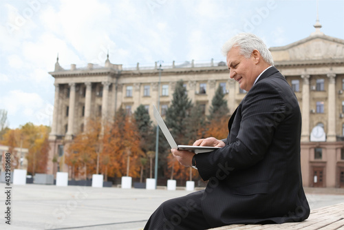 Senior businessman using la...