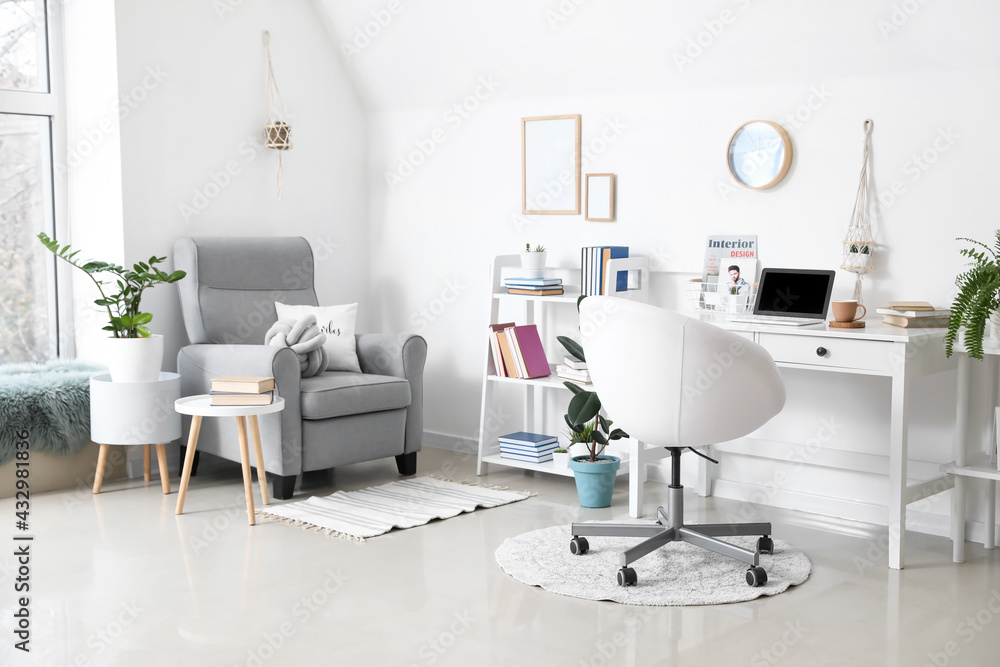 Comfortable workplace and armchair in interior of light room