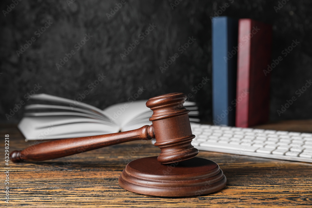 Judge's gavel and law book on dark wooden background Judge's gavel and law book on dark wooden background
