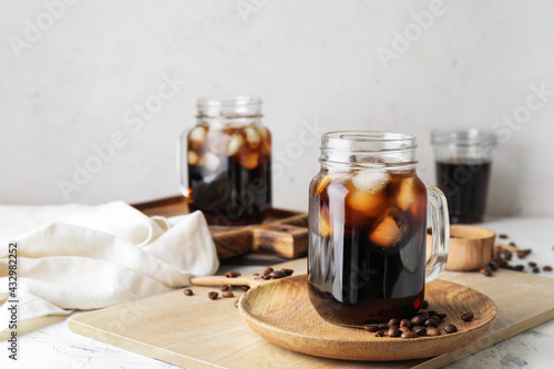 Fotomurale Mason jars of tasty cold brew and coffee beans on white background