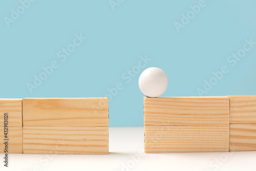 Wooden ball on high wall and needs to be passed to the other side over a gap .Problem solving and decision making. Deadlock, search for a solution
