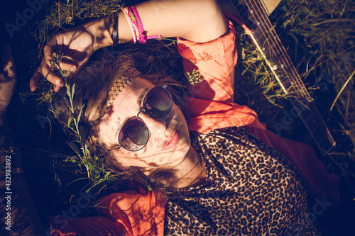 nature, summer vacation, vacation and people concept - happy smiling woman in sunglasses lies on the grass in a summer field. photo