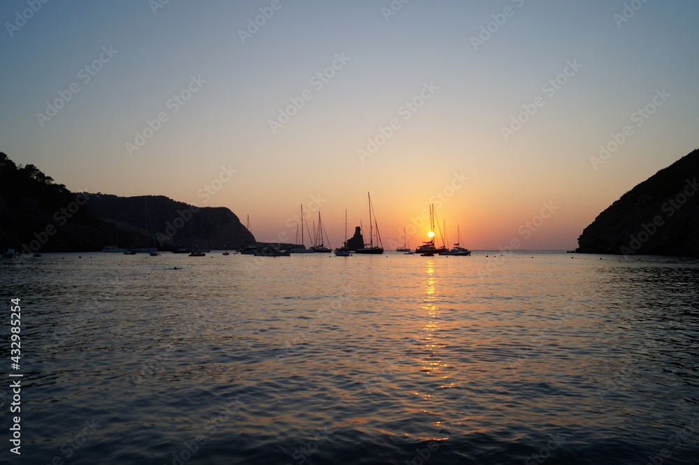 a beach on the island of Ibiza with boats at dusk on a summer night. Balearic Islands, Spain


