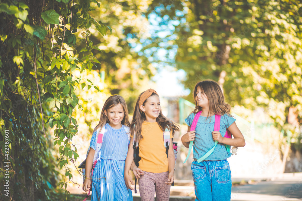 Back to school. Three little girls walking trough nature with school bag on back. Back to school. Three little girls walking trough nature with school bag on back.