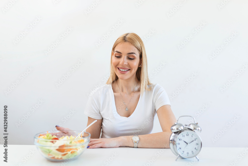 Time to lose weight , eating control or time to diet concept. Retro alarm clock in which woman make Intermittent fasting with a Healthy food of salad. Time to lose weight , eating control or time to diet concept. Retro alarm clock in which woman make Intermittent fasting with a Healthy food of salad.